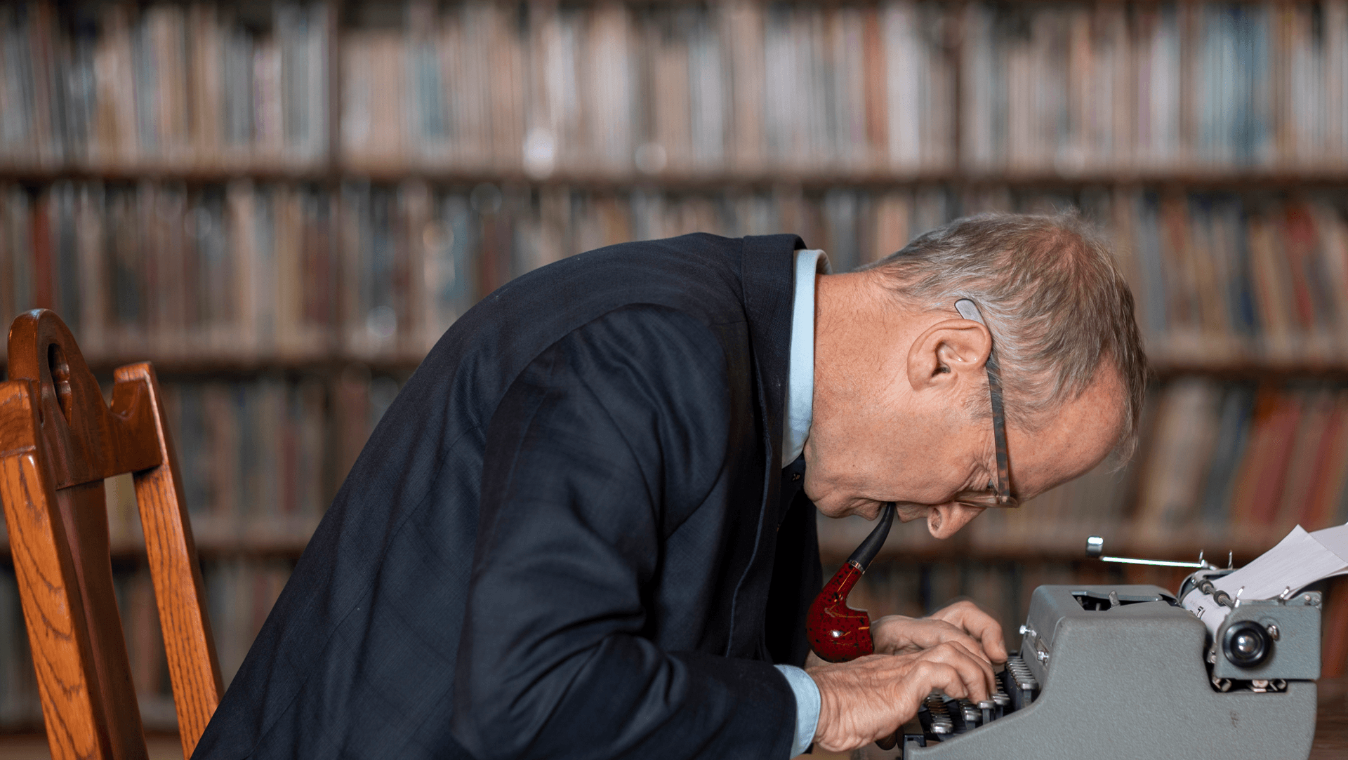 Author David Sedaris hunched over a typewriter